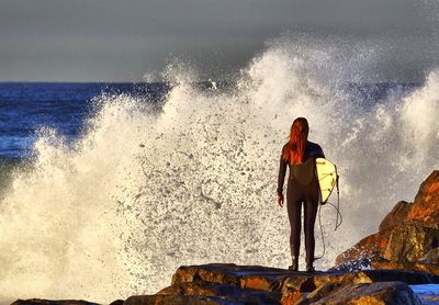 People on rocks at sea shore