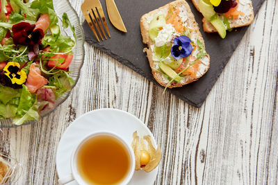 Healthy pescetarian breakfast - toasts, fresh salad. appetizer with salmon, cottage cheese, flowers