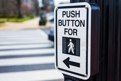 Close-up of push button with text and arrow symbol