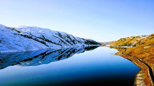 Scenic view of snowcapped mountains against clear blue sky