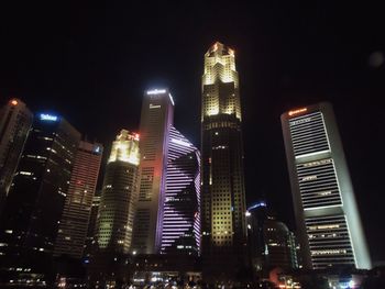 Low angle view of illuminated buildings against sky at night