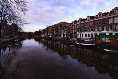 Canal amidst buildings against sky