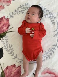 High angle view of baby girl lying on bed