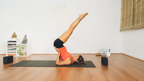 Mid-age woman practicing yoga in a yoga studio