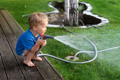 Boy playing with water in park