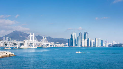 View of city by sea against sky