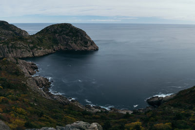 Rock formations by sea against sky