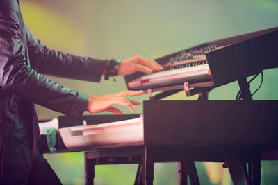 Midsection of man playing piano