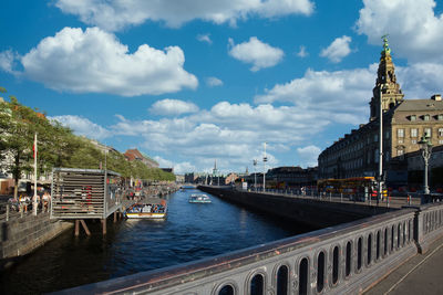 View of buildings in city against cloudy sky
