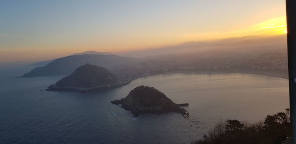 Scenic view of sea and mountains against sky during sunset