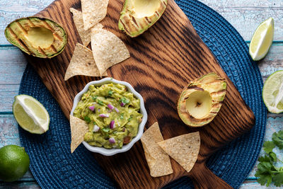 Top down view of a dish of freshly made guacamole surrounded by tortilla chips.