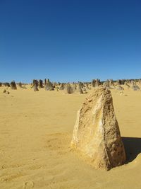 Scenic view of desert against clear blue sky