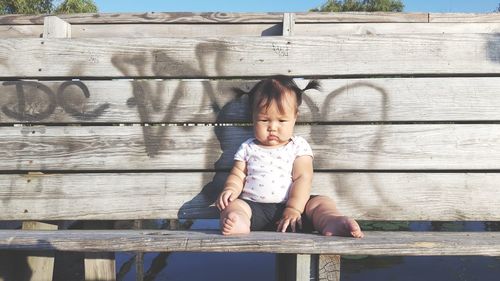 Full length of girl sitting on table outdoors