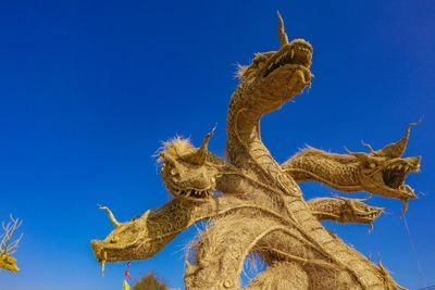 Low angle view of giraffe against clear blue sky