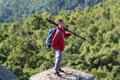 Full length of man standing on mountain in forest