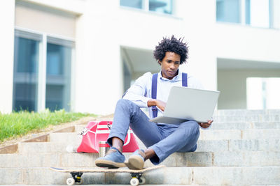 Young man using mobile phone while sitting in office