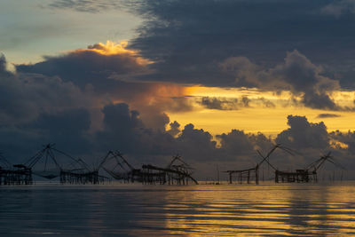 Traditional fishing nets made from bamboo and wood over sunrise at phatthalung, thailand.