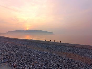 Scenic view of beach against sky during sunset