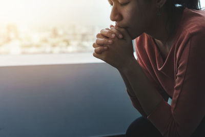 Close-up of woman looking away while sitting on floor