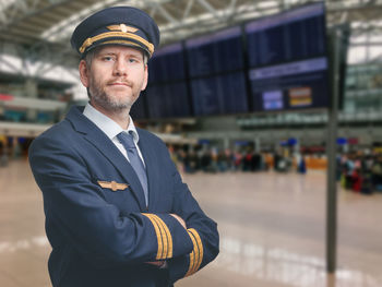 Portrait of pilot standing at airport