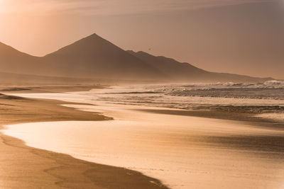 Scenic view of beach against sky during sunset