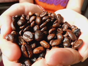 Cropped image of hands holding coffee beans