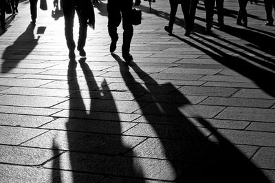 Shadow of people walking on footpath