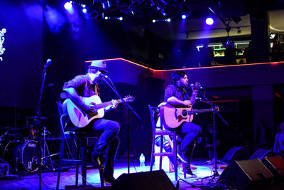 People playing guitar at music concert