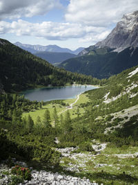 Scenic view of lake by mountains against sky