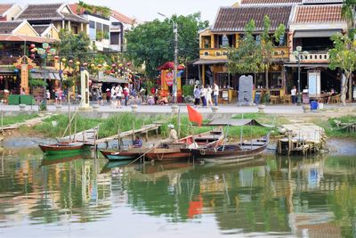 Boats in canal by buildings in city