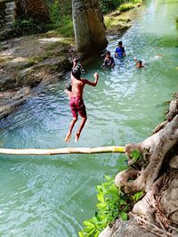 Rear view of people walking on rock in water