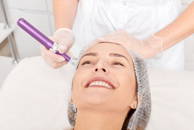 Portrait of smiling young woman holding syringe