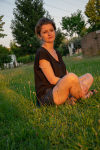 Portrait of young woman sitting on field