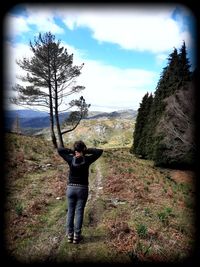 Full length of man standing by tree against sky