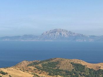 Scenic view of sea and mountains against sky