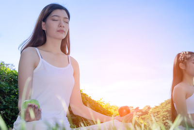 Beautiful woman standing against sky