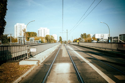 Railroad tracks in city against sky