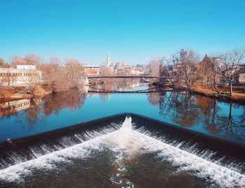 River amidst buildings against blue sky