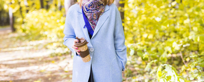 Portrait of woman holding ice cream standing outdoors