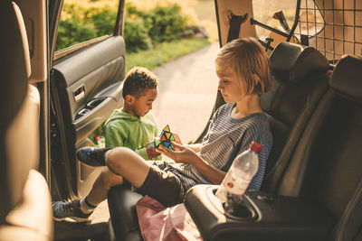 Rear view of boys sitting in car