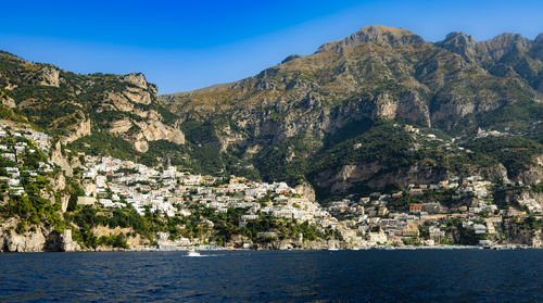 Scenic view of sea and mountains against clear sky