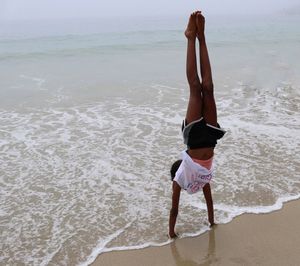 Full length of young woman standing on beach