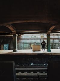 Person standing at railroad station platform