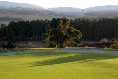 Scenic view of golf course against sky