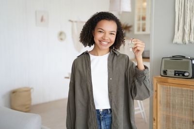 Young woman standing against wall