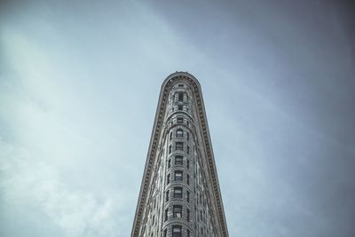 Low angle view of flatiron building against cloudy sky