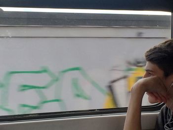 Close-up of man seen through train window
