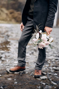 Low section of man standing on rock