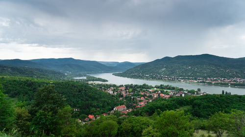 Scenic view of townscape by mountains against sky