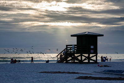 People on beach by sea against sky